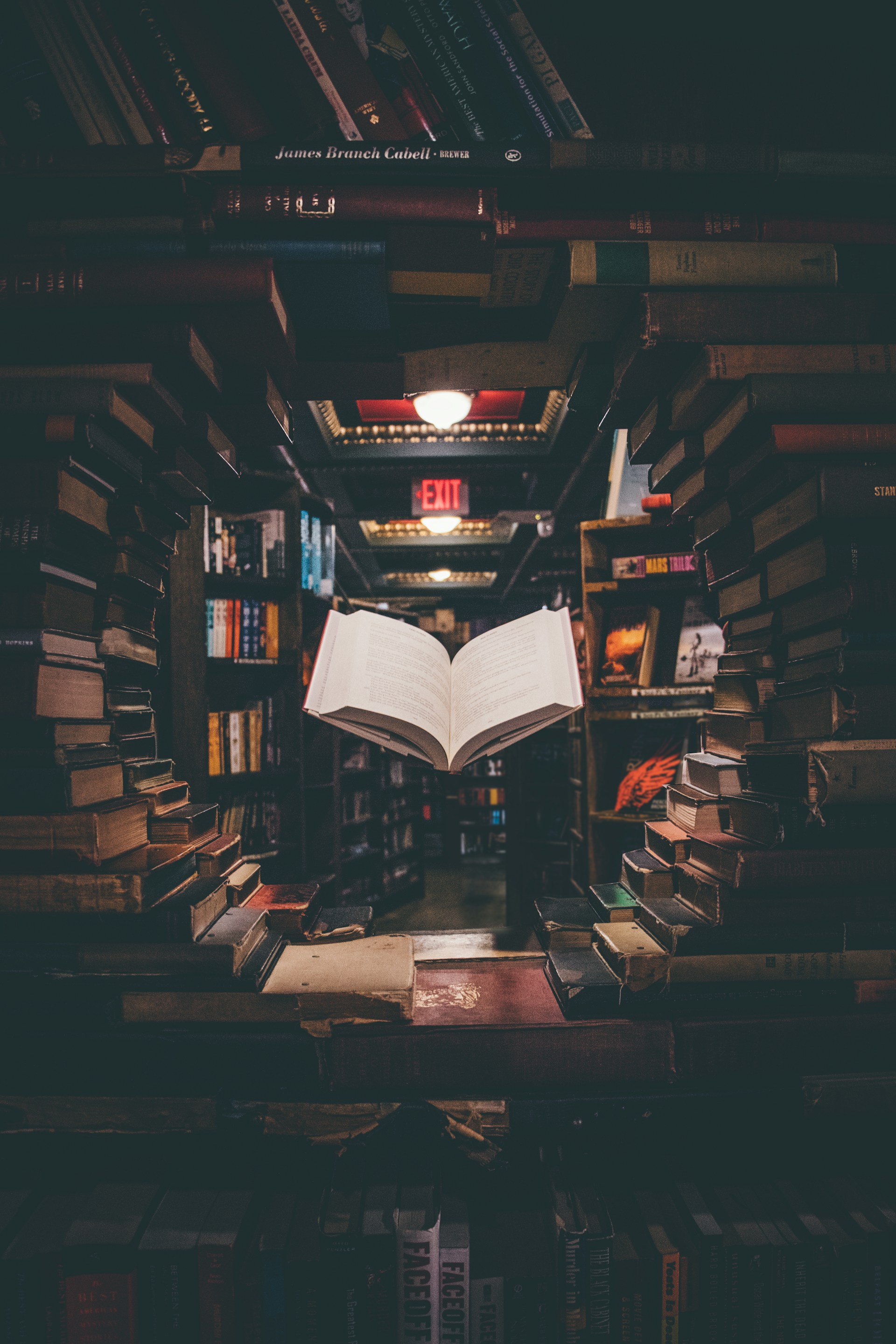 An open book in a library with a circule of book surrounding.