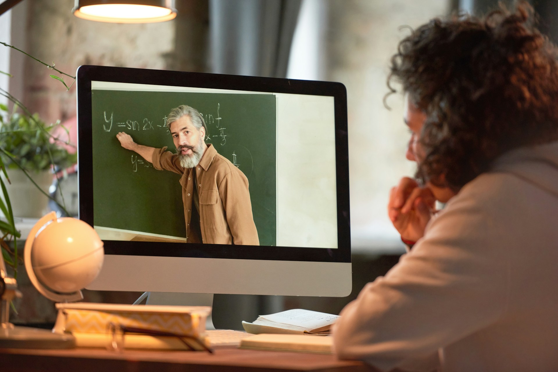 an online course creator standing in front of a green chalkboard